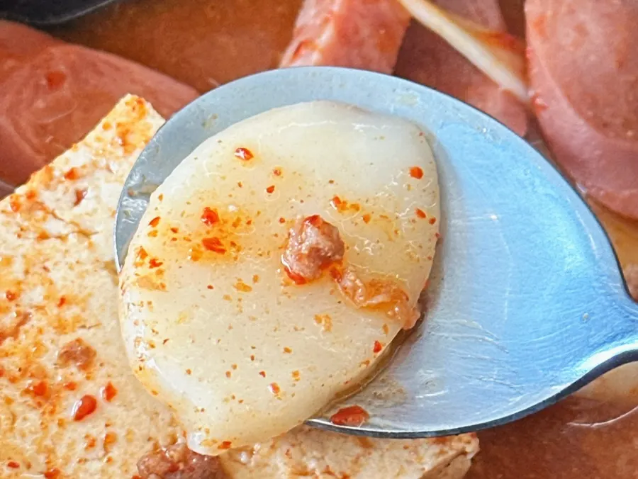 A spoonful of rice soaked in budae-jjigae broth