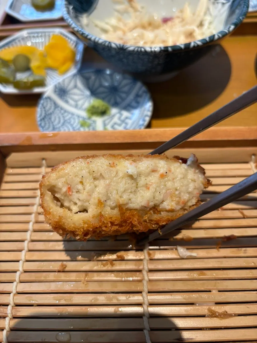 A piece of croquette dipped in sauce