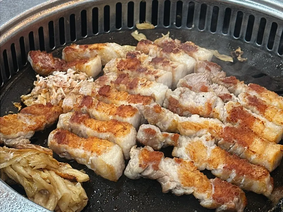삼겹살 위에 올린 묵은지와 유자무생채