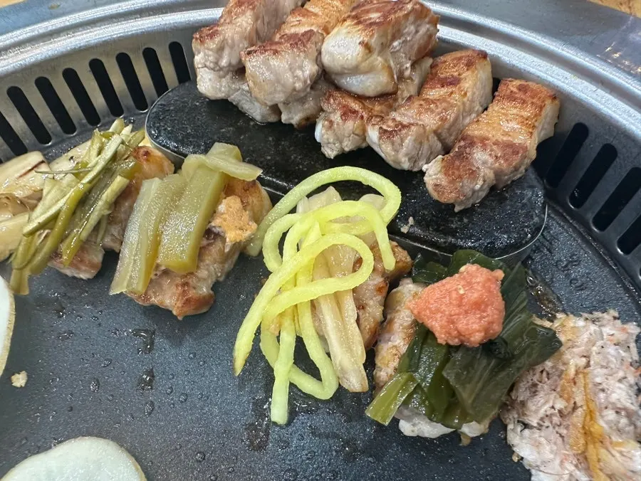 A piece of pork belly topped with a side dish