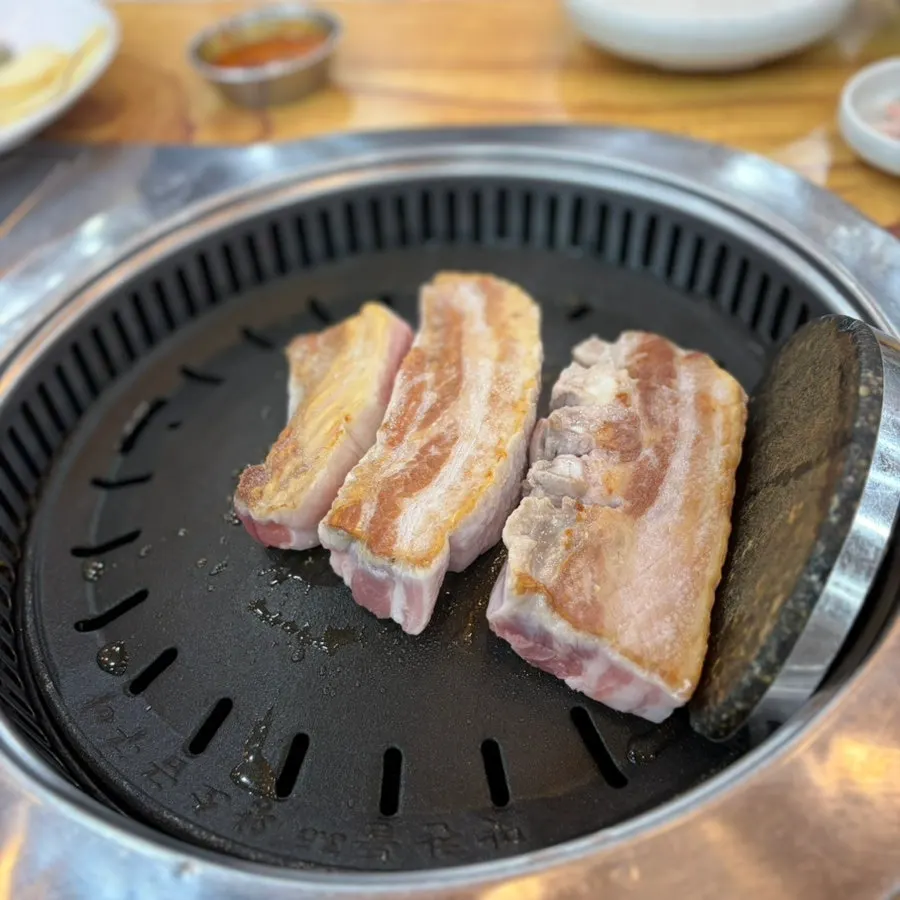 Staff member grilling pork belly on the grill