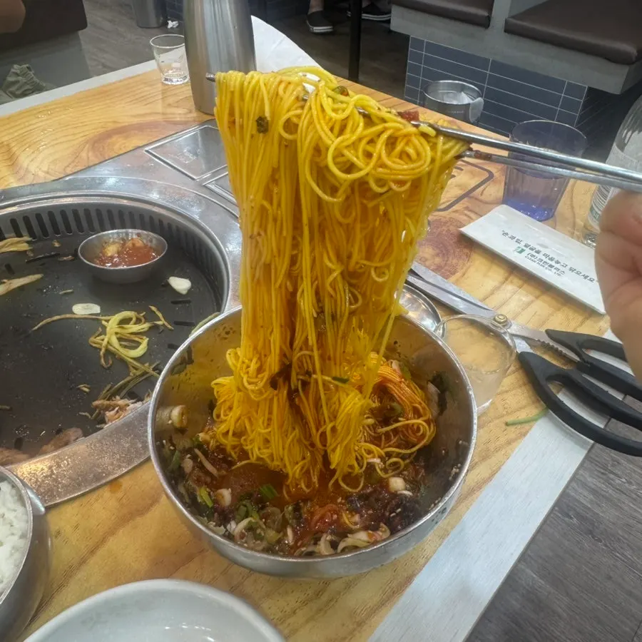 익힌 묵은지를 올린 삼겹살 한 점