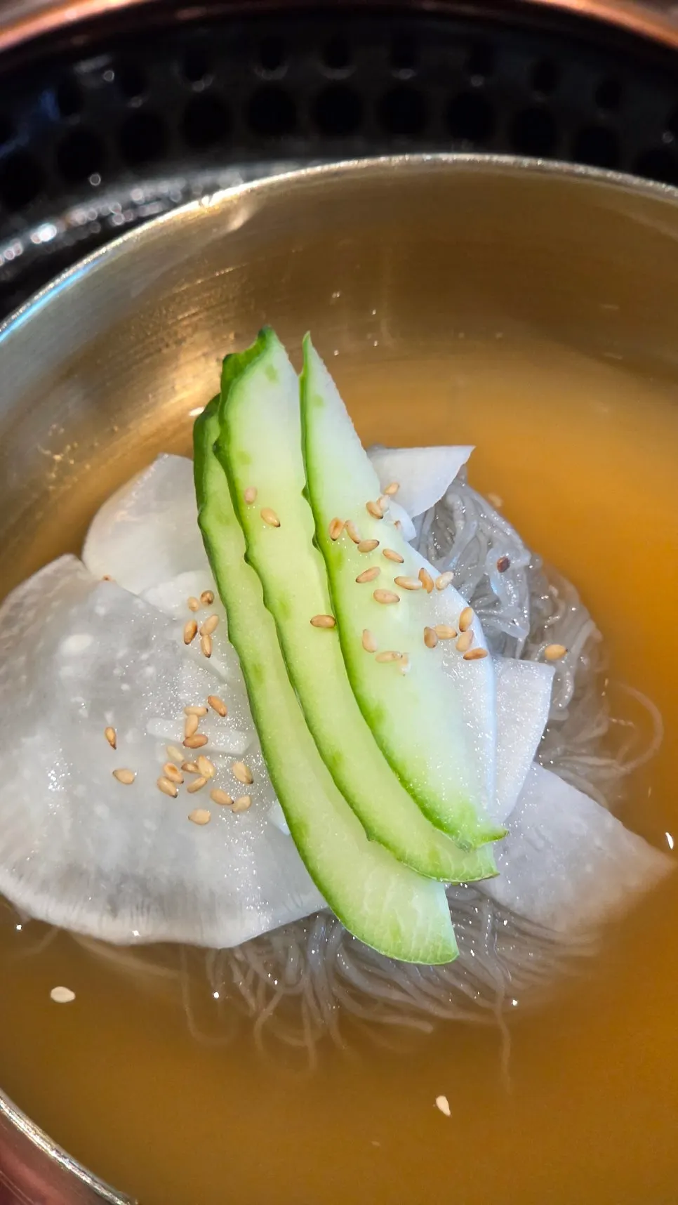 Bibim naengmyeon topped with boiled pork, cucumber, and sauce