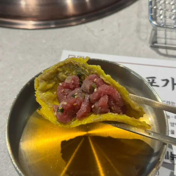 육전에 육회를 올려 싸 먹는 모습