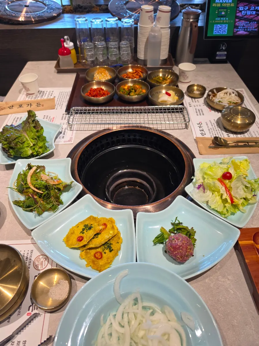 Generous basic side-dish spread around a charcoal brazier