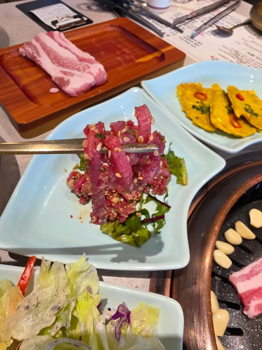 Complimentary yukhoe with sesame seeds and vegetables