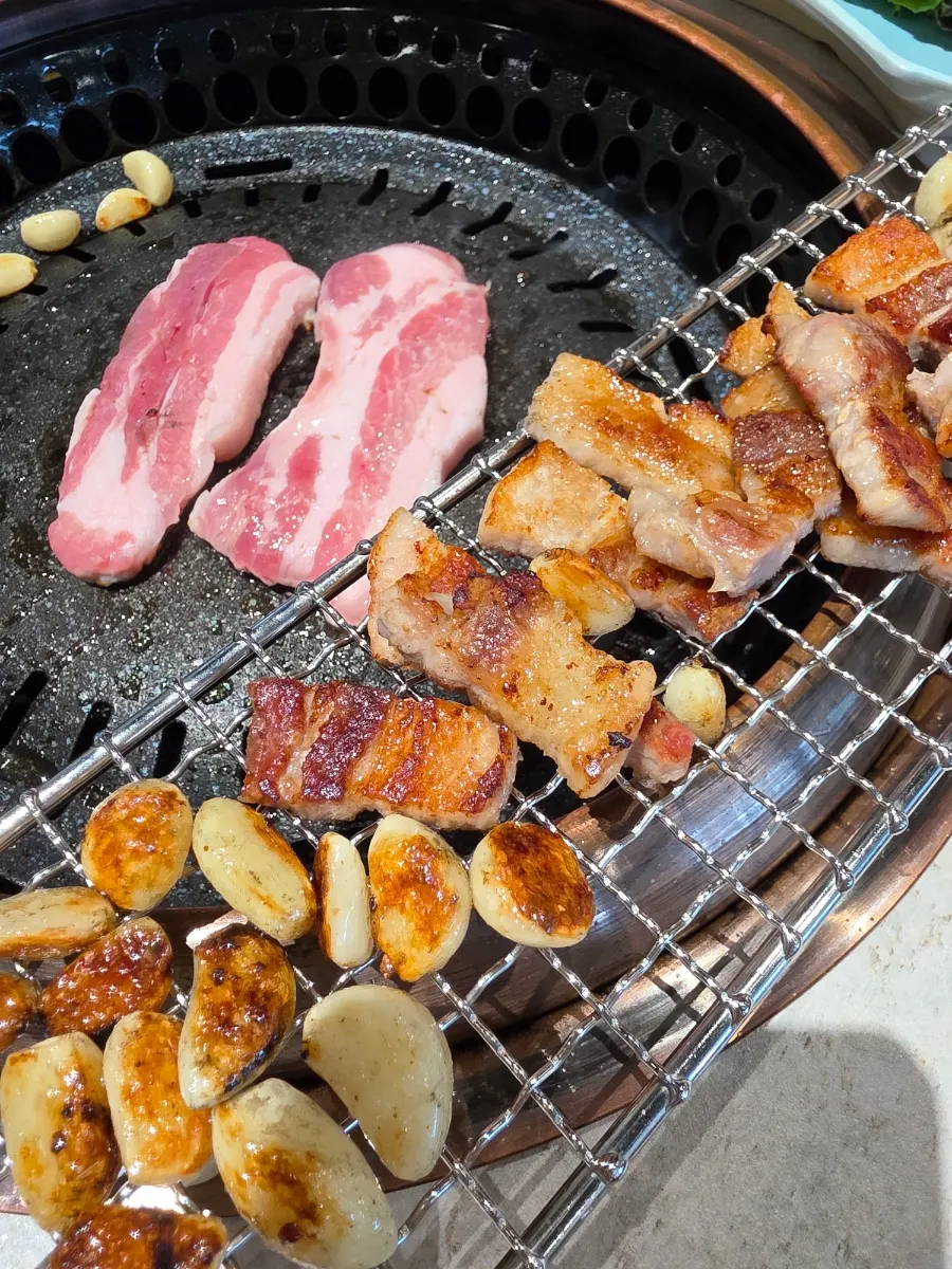 Pork belly grilling over charcoal