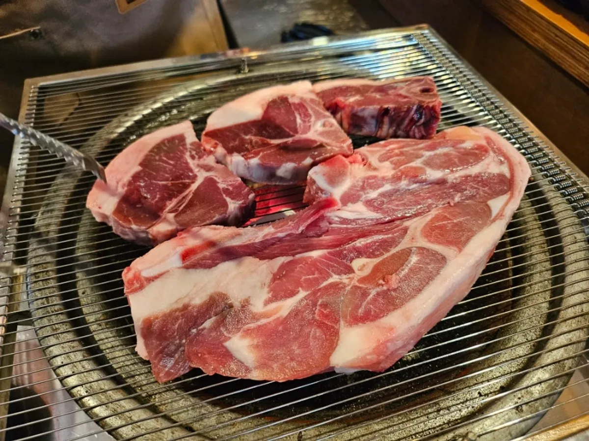 Charcoal grill and the first round of lamb at the table