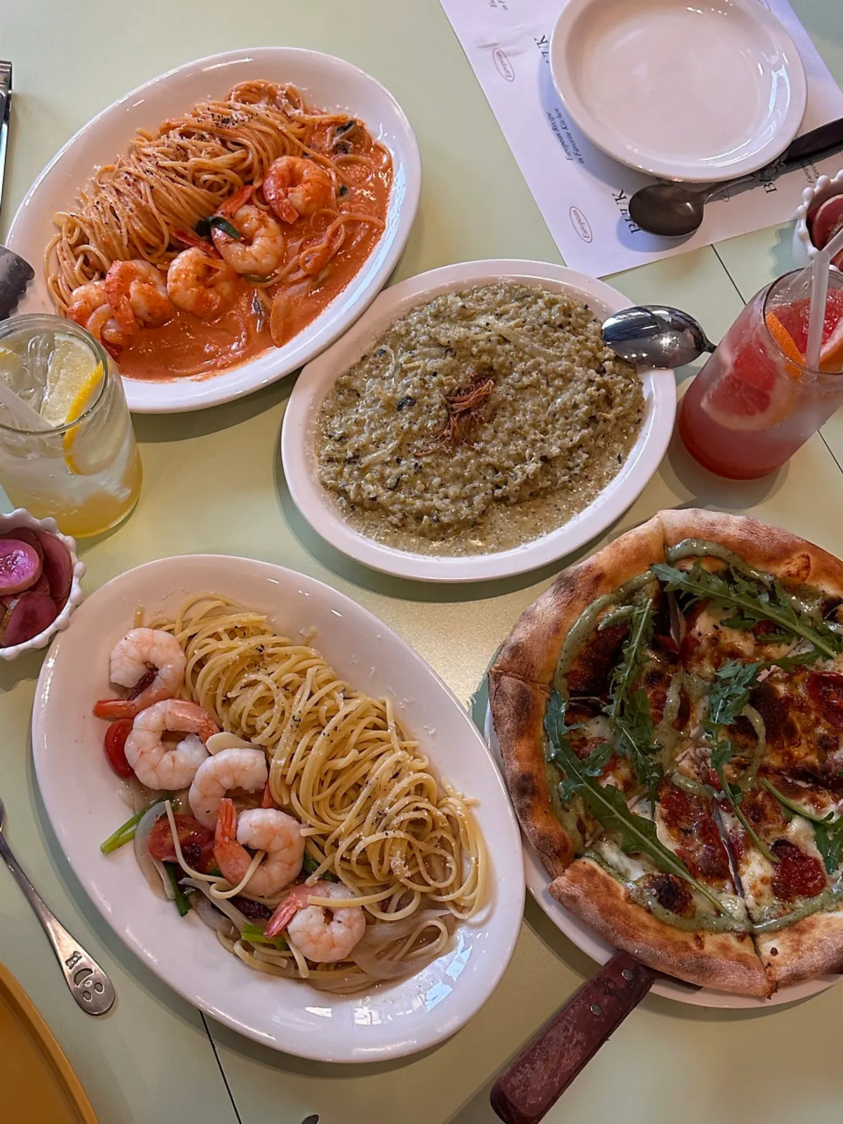 Table set with two pastas, risotto and pizza