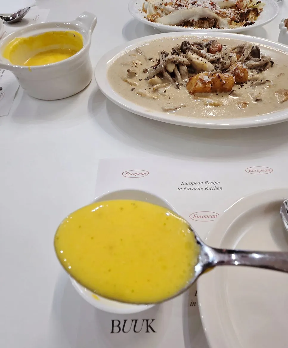 A spoonful of sweet pumpkin soup being eaten