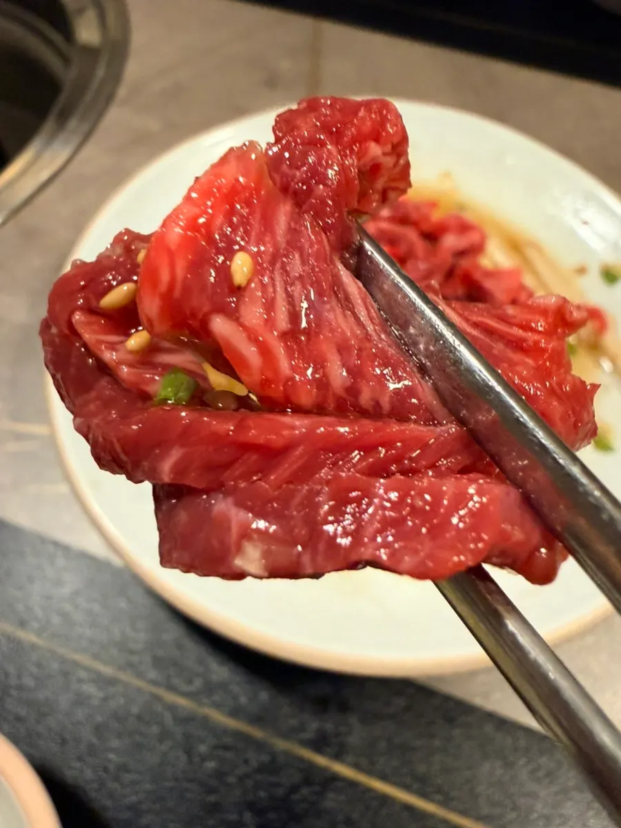 A thick piece of yukhoe picked up with pear underneath