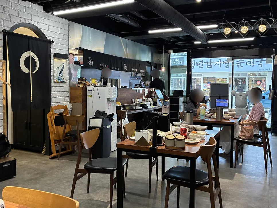 화이트 벽돌과 원목 테이블의 시로쿠마 매장 내부