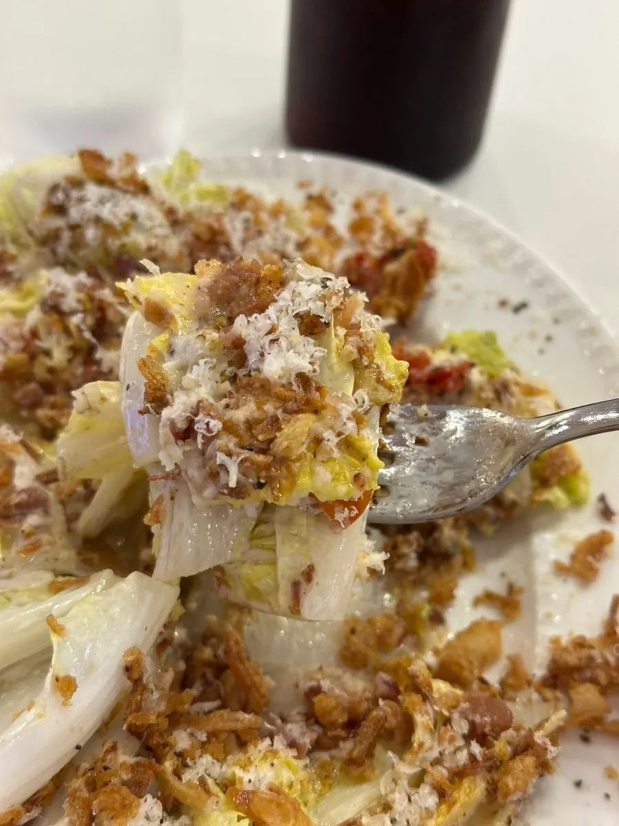 Close-up of Caesar salad with sun-dried tomatoes and bacon chips