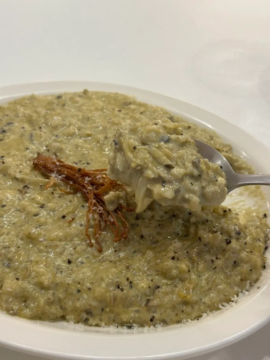 A spoonful of cream risotto topped with abalone