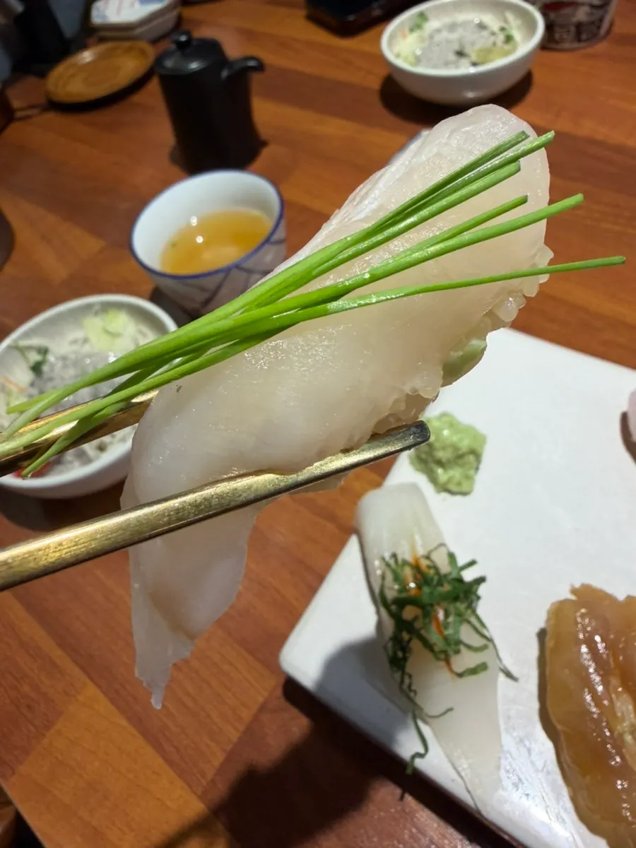 Flounder sushi topped with pine needle garnish