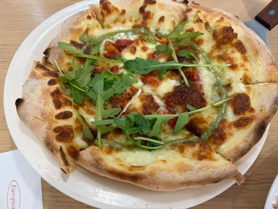 Caesar salad served between pasta and pizza