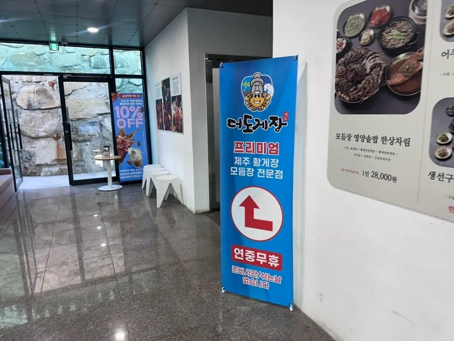 Menu board hung outside showing Deodo Gejang's table spread