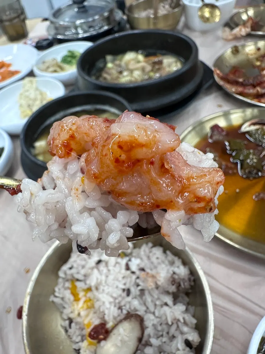 A spoonful of pot rice topped with spicy crab meat