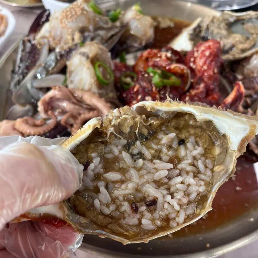 Picking up a piece of spicy marinated crab
