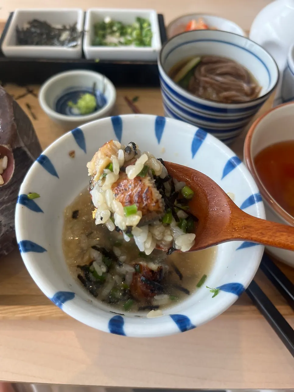 Eel rice bowl topped with seaweed flakes, scallions, and wasabi