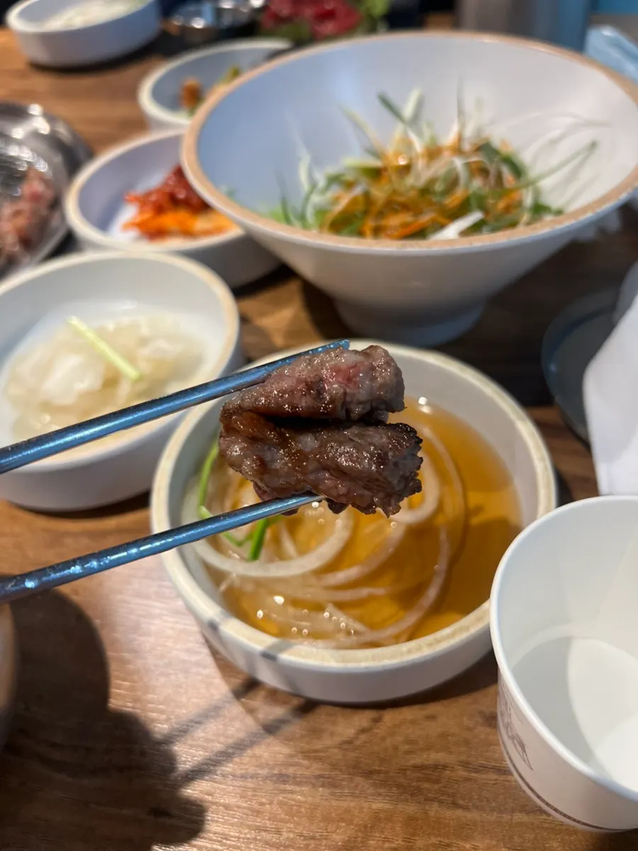 Grilled beef and side dishes laid out on the table
