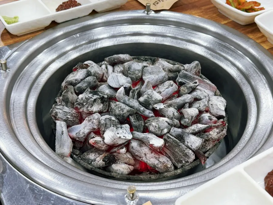 Meat grilling over charcoal at Yeoyejeong