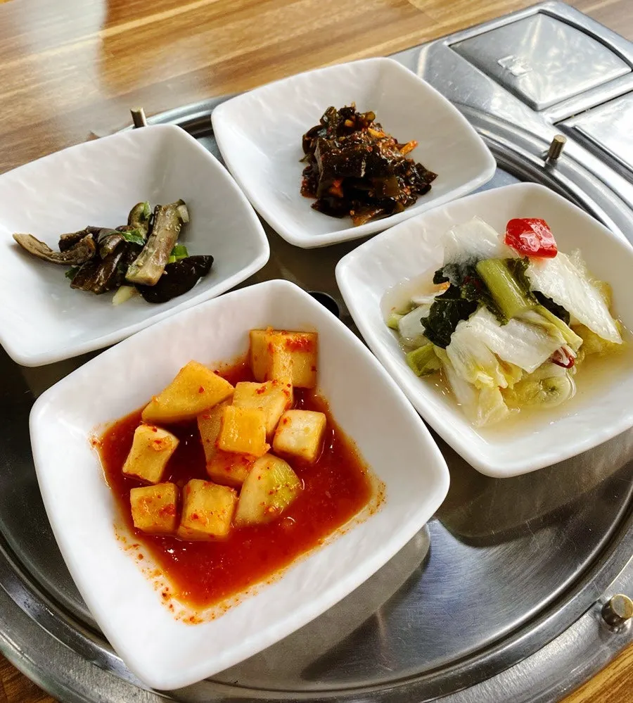 Basic side dishes at Yeoyejeong including diced radish kimchi and white kimchi