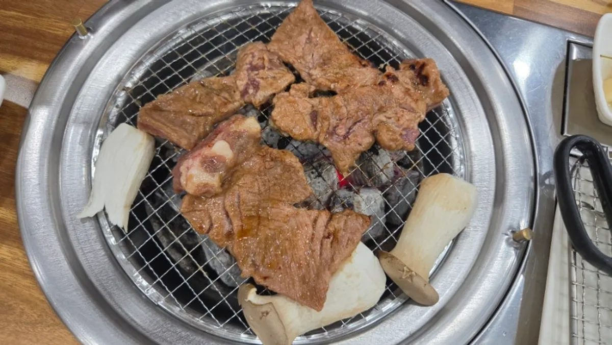 Close-up of marinated galbi grilling over charcoal