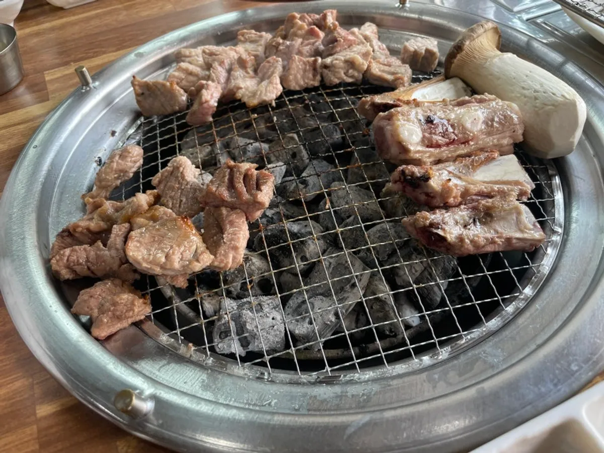 Fresh pork ribs and whole mushroom grilling over charcoal