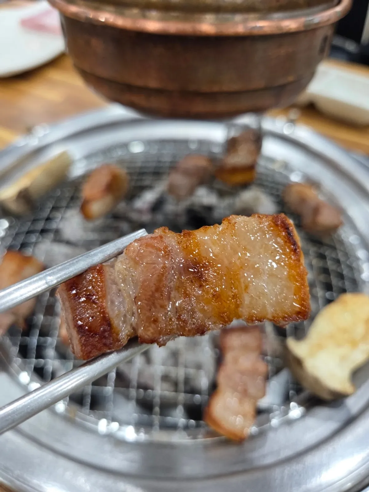 Aged pork belly grilling over charcoal