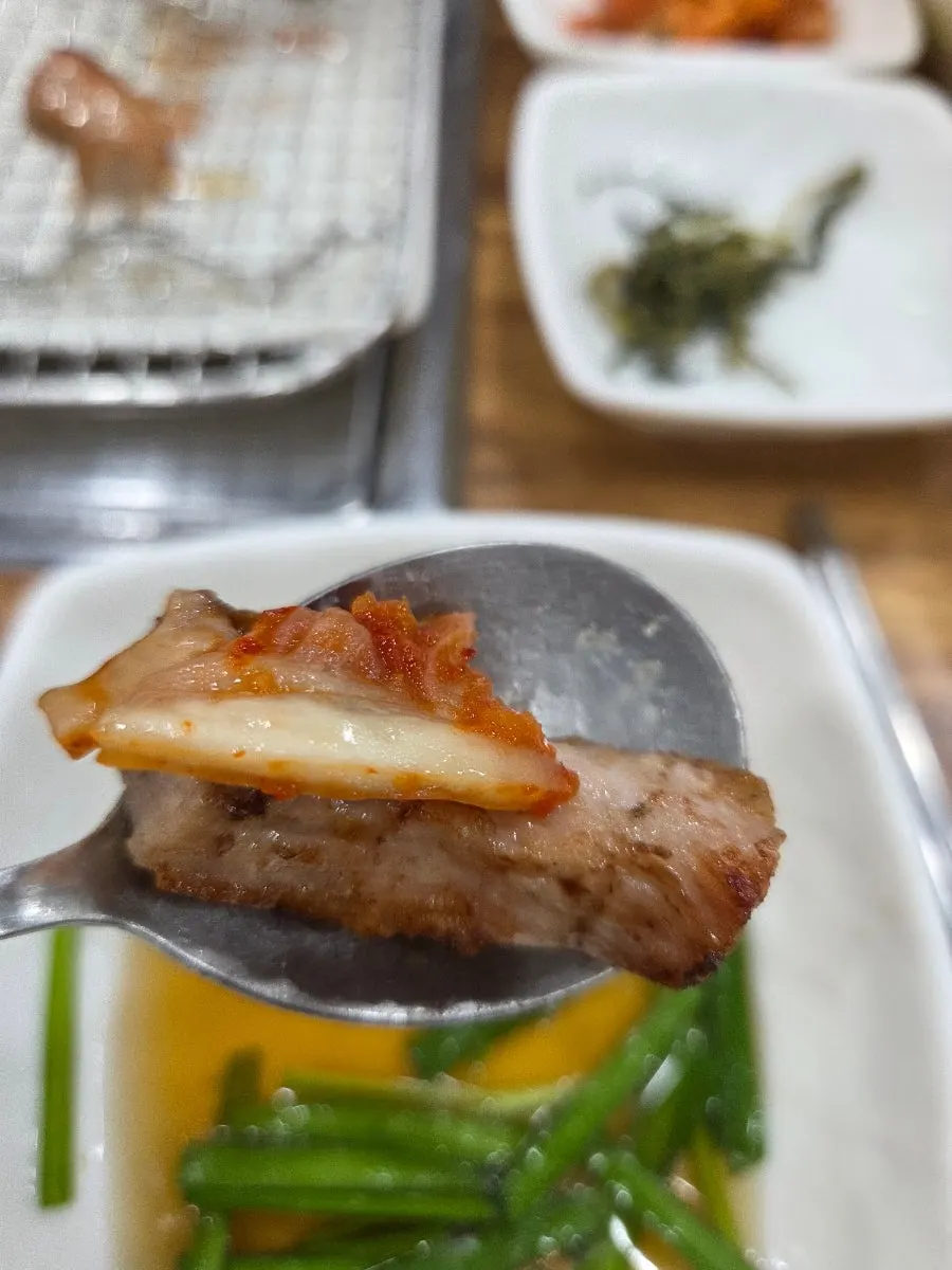 A piece of pork jowl topped with kimchi