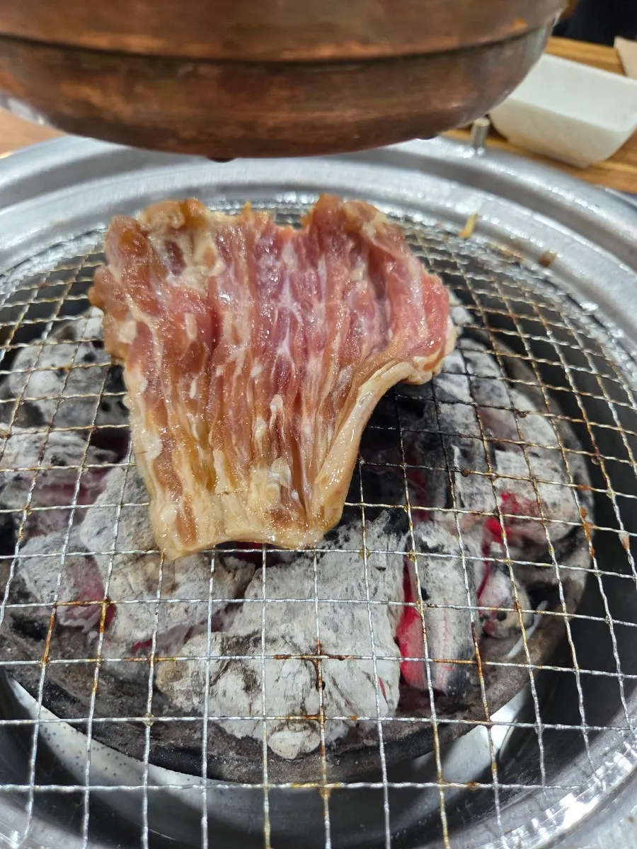 Marinated pork ribs grilling over charcoal