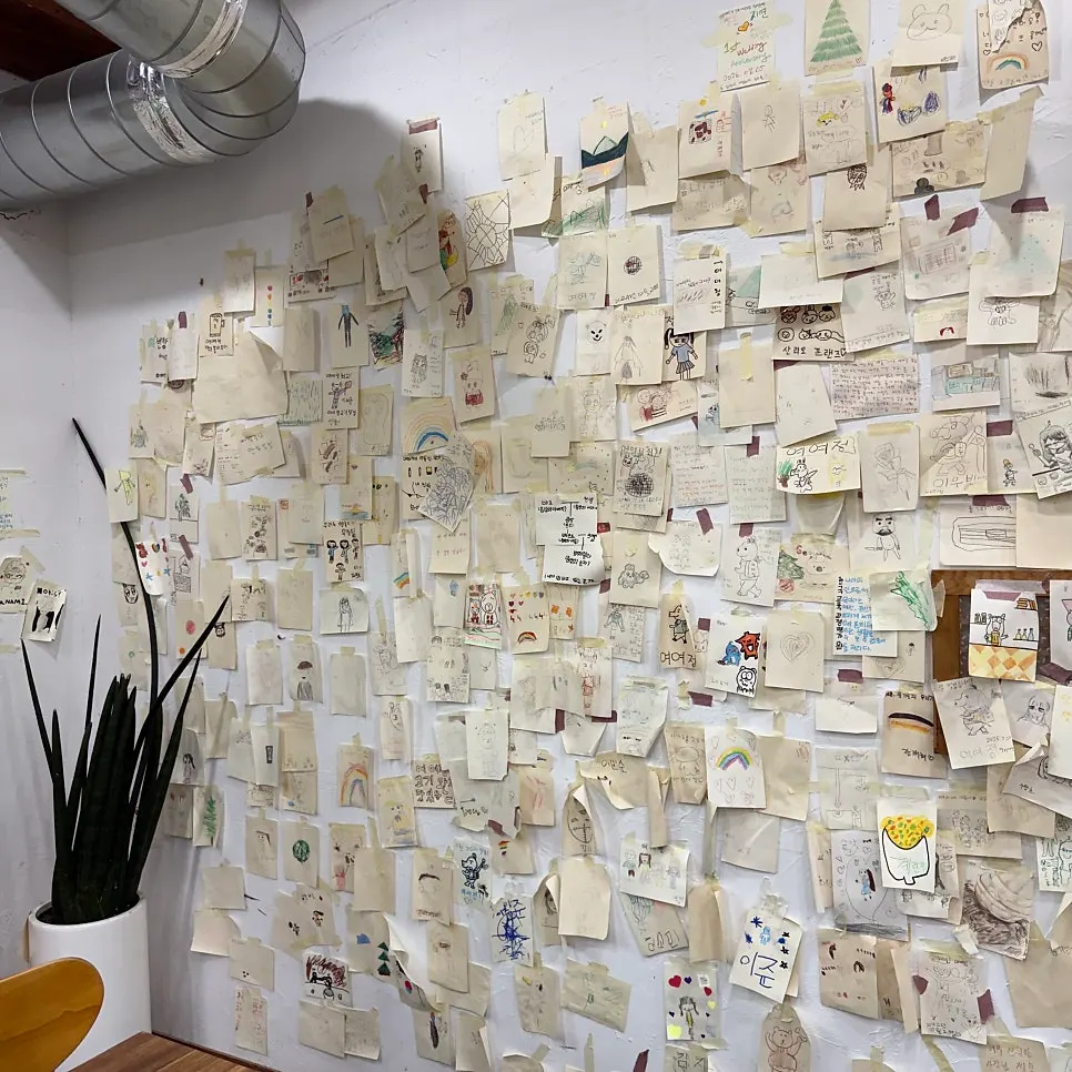 Wall covered with customer drawings and notes at Yeoyejeong