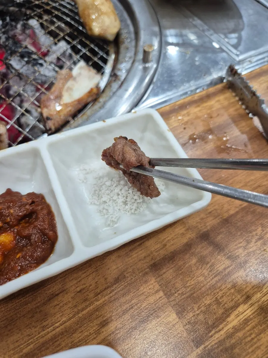 Fresh galbi and dipping sauces on the grill