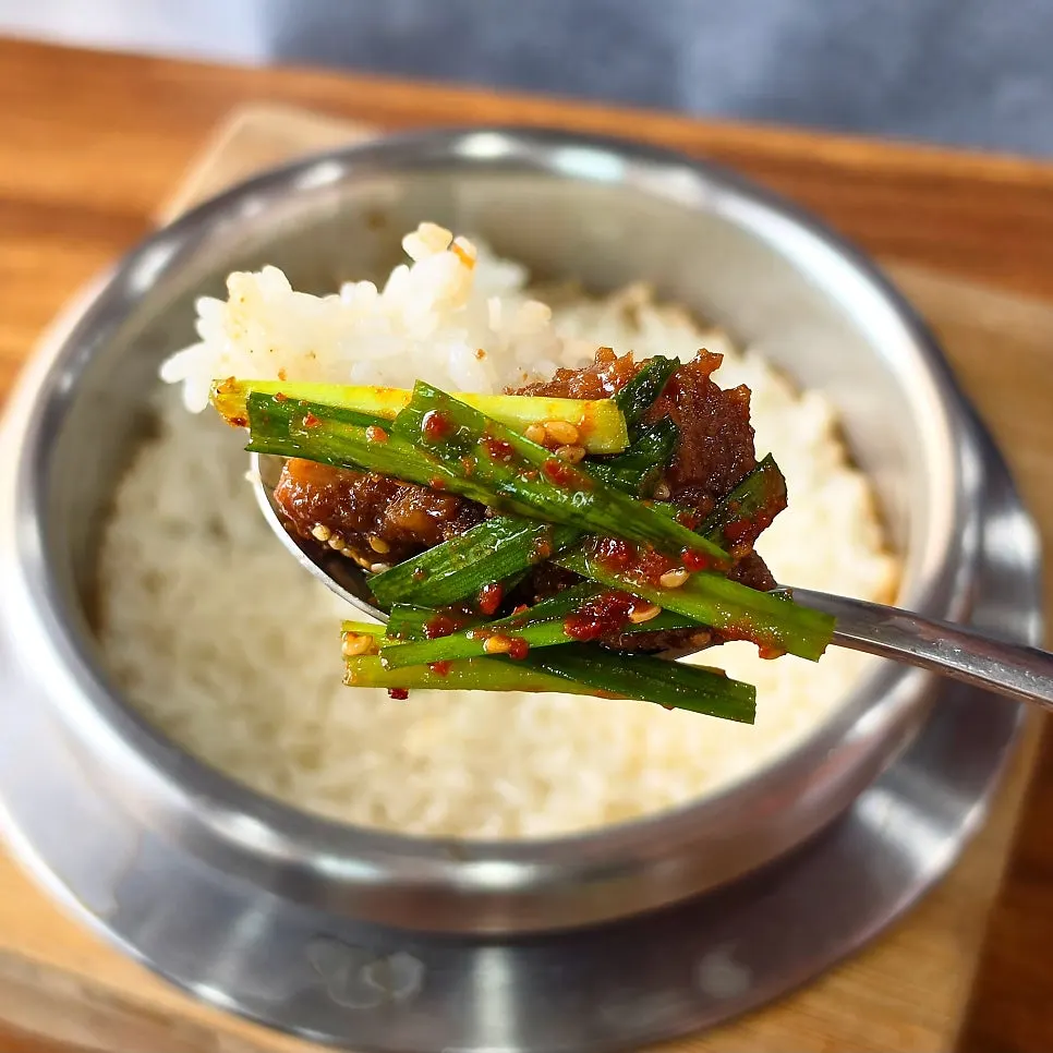 A piece of meat topped with pickled chives