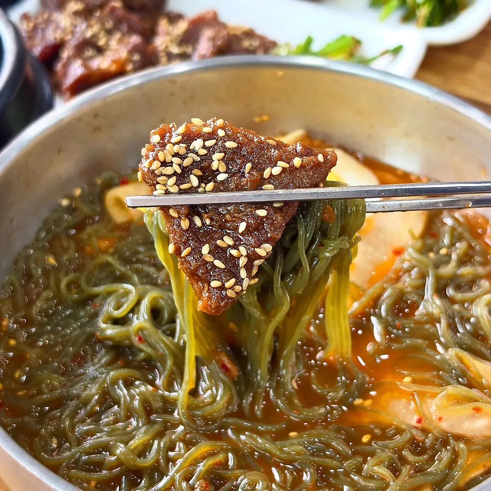 A bite of meat and noodles together from the meat naengmyeon