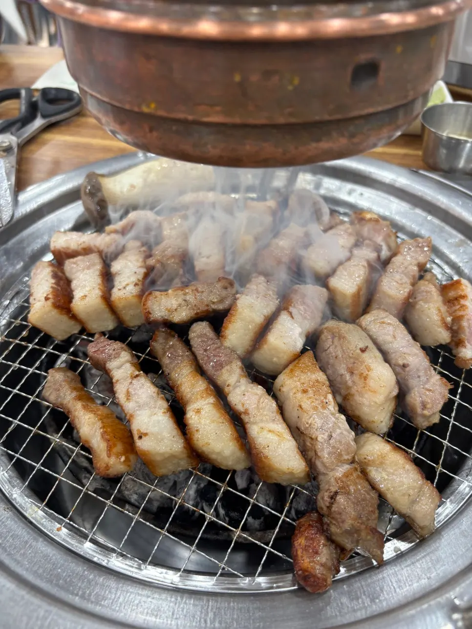 Pork belly grilling to a golden brown on the grill