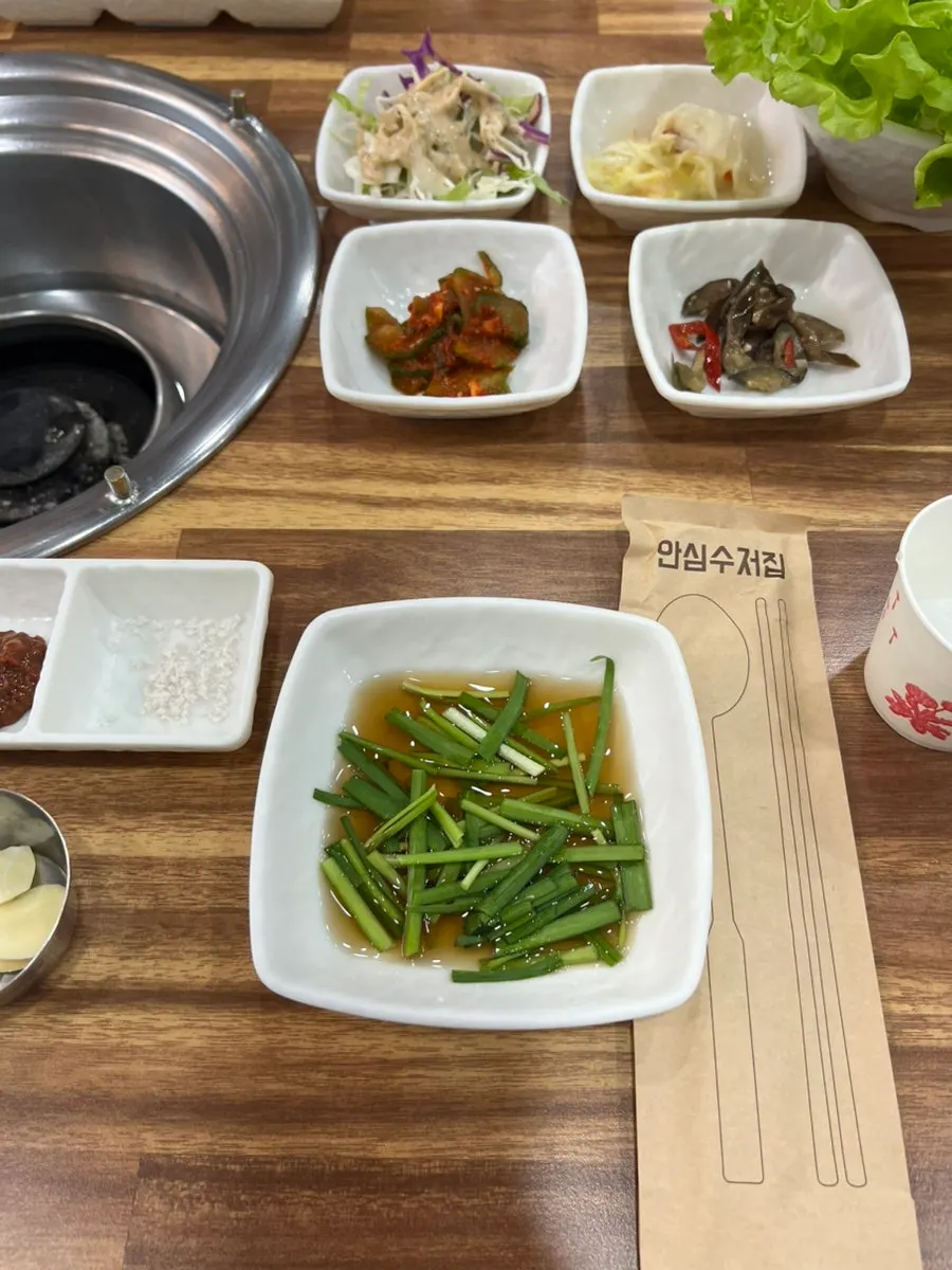 Side dishes and a fresh bundle of lettuce at Yeoyejeong