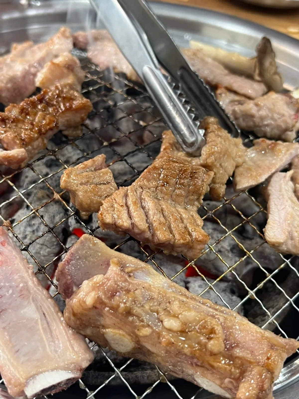 Marinated and fresh ribs grilling over charcoal