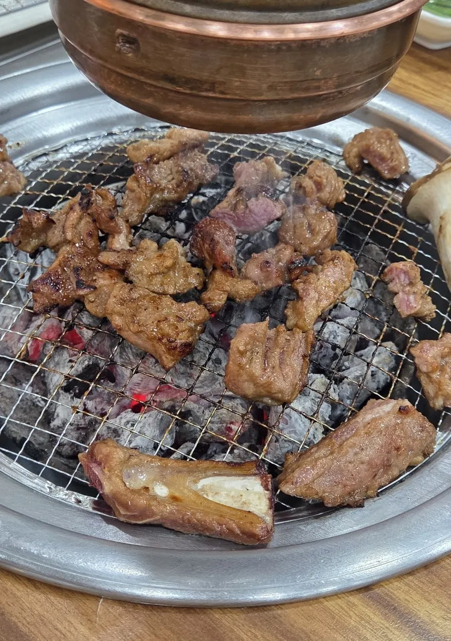 Marinated ribs grilling over charcoal