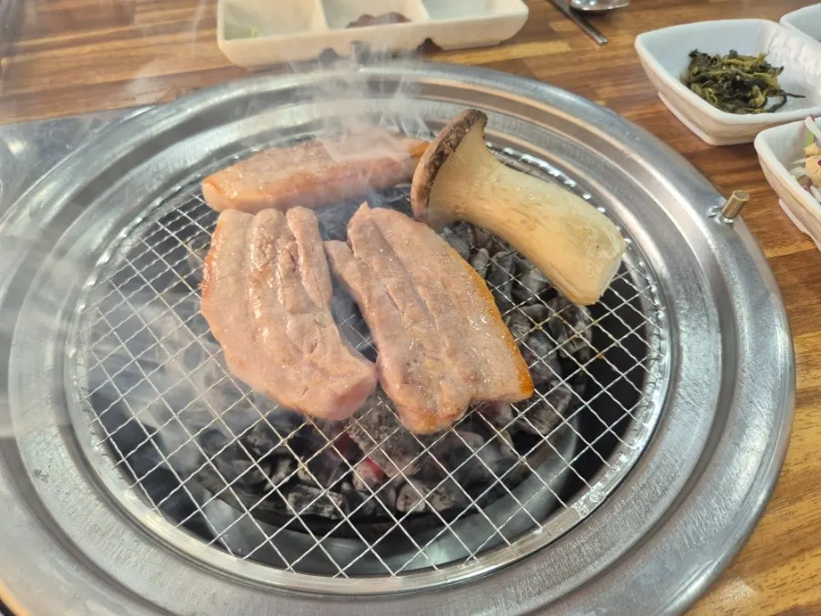 King oyster mushroom grilling alongside pork belly