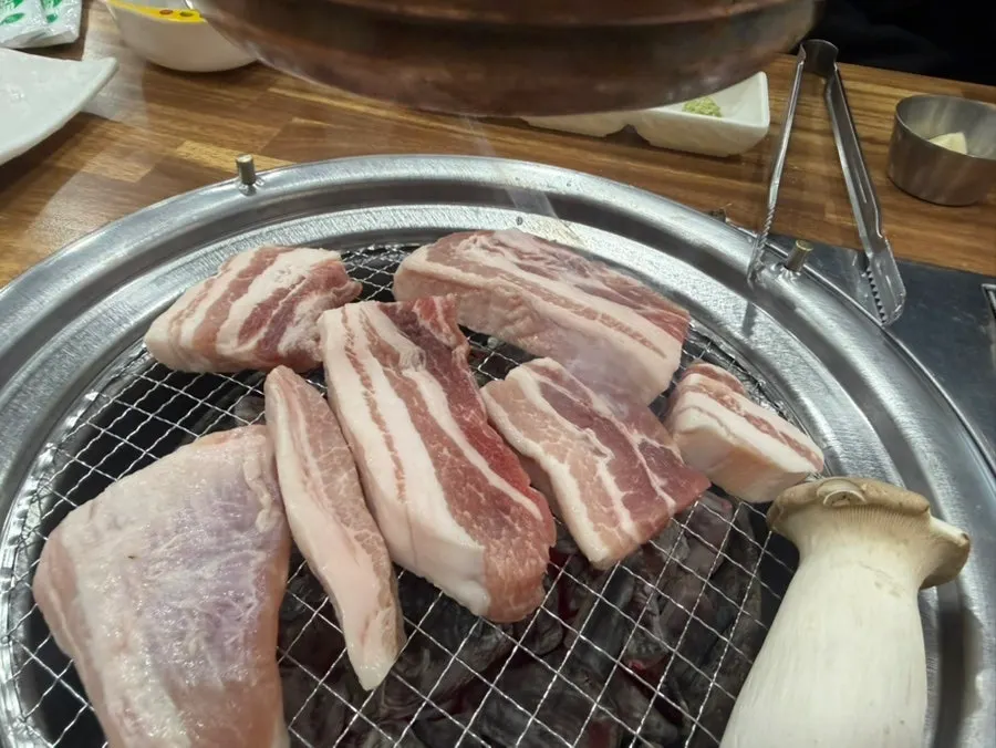 Thick pork belly placed on the charcoal grill
