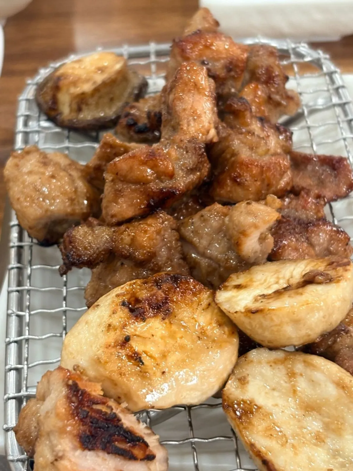Pork galbi and grilled mushrooms resting on the grill rack