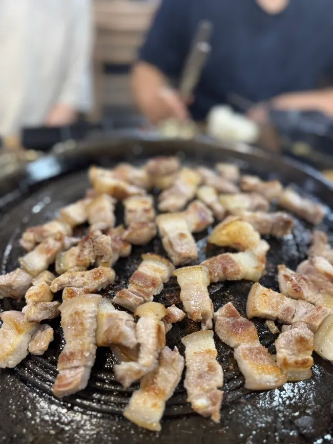 Black pork belly grilling on the cast-iron pan