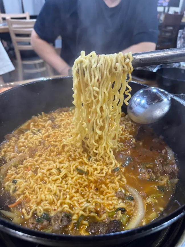 Hanwoo hangover ramyeon simmering in the cast-iron pan