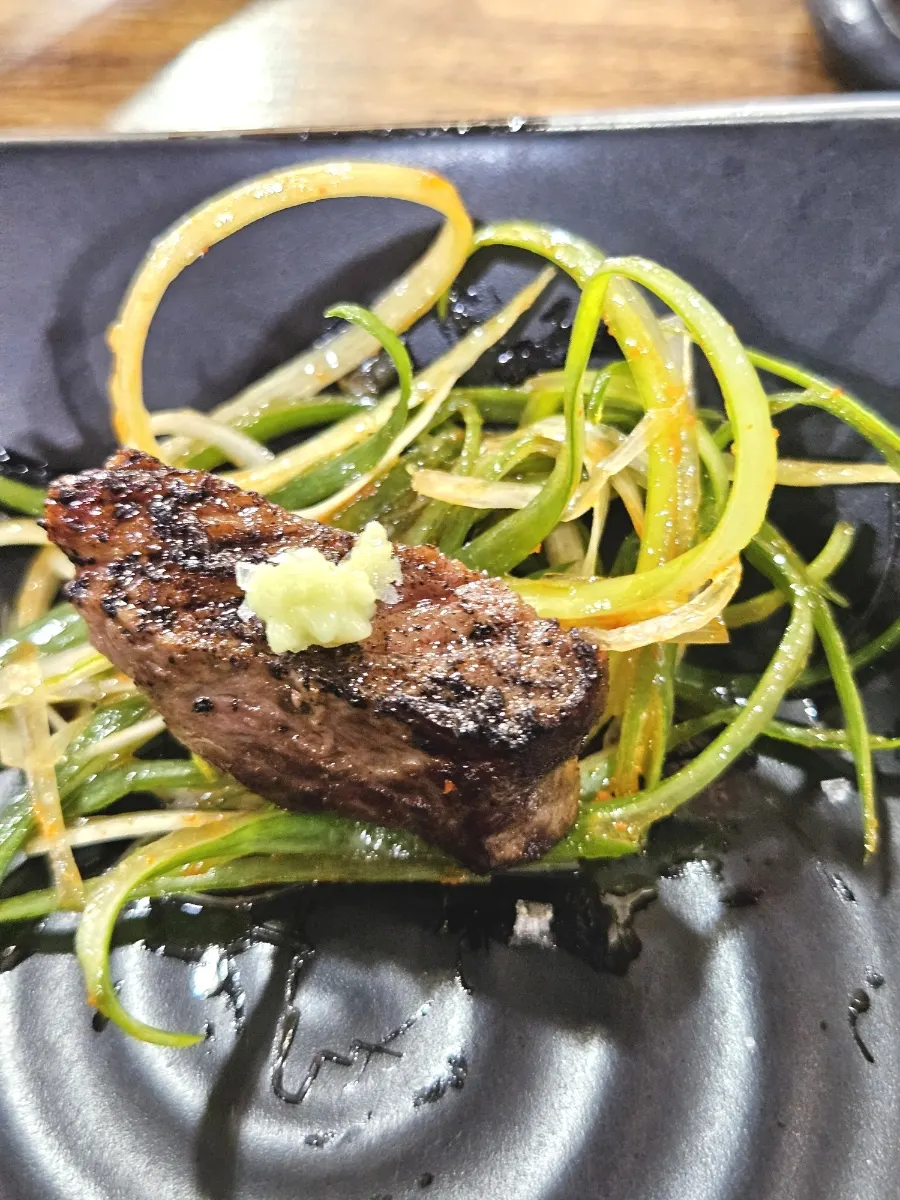 A piece of hanwoo sirloin picked up with chopsticks