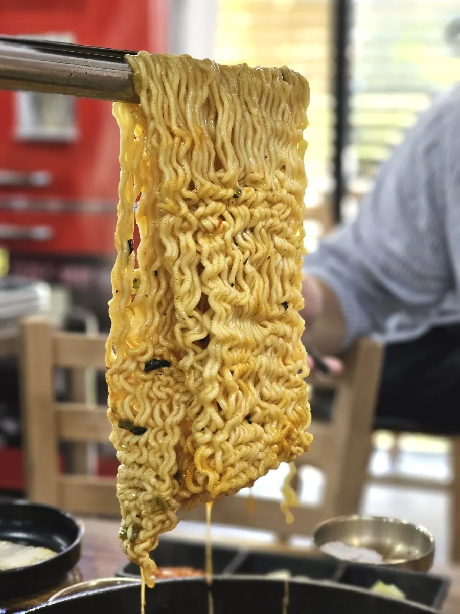 Lifting the noodles with tongs