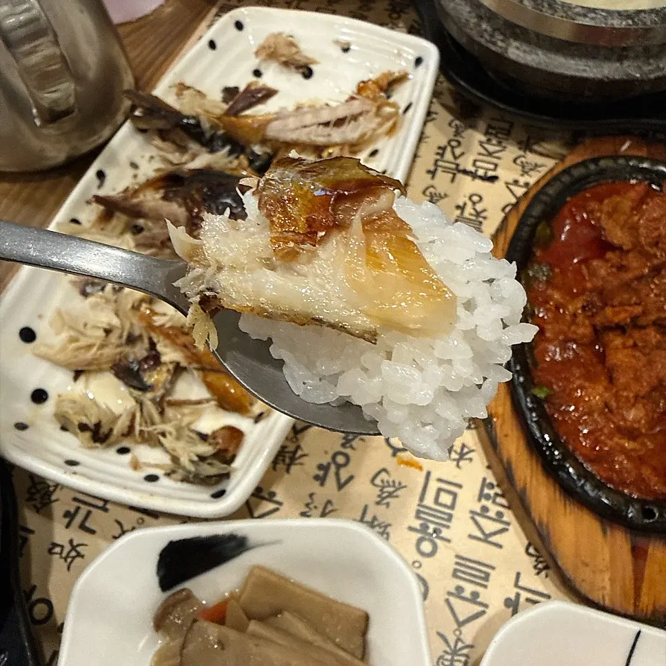 A piece of grilled mackerel over white rice