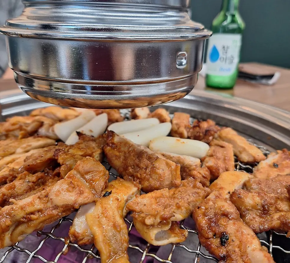 Pre-grilled seasoned dakgalbi finishing over charcoal