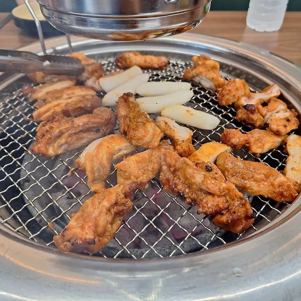 Seasoned dakgalbi placed on the charcoal grill